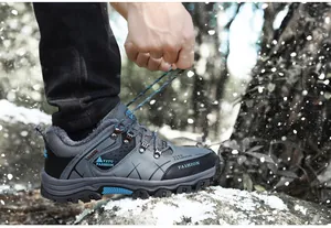 Detalle de botas de montaña de invierno con forro de felpa y detalles azules en la nieve