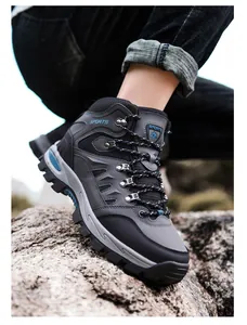 Detail von Outdoor-Wanderschuhen mit robuster Gummisohle und Metallösen auf Felsen