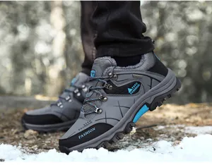 Detalle de botas de senderismo de invierno grises con forro de piel cálido y ojales metálicos