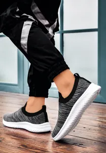 Detail of grey slip-on walking shoes featuring breathable knit fabric and thick white MD soles