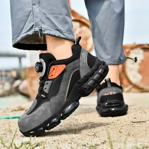 Safety work shoes with steel toe and rotary buckle closure on a rugged outdoor terrain