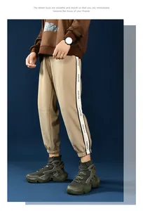 Detail shot of khaki joggers with white side stripe and high-top sock sneakers for men