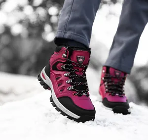 Dettaglio scarponi da trekking fucsia con suola spessa antiscivolo sulla neve