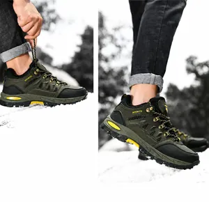 Detalle de botas de senderismo verde militar con suelas antideslizantes en la nieve