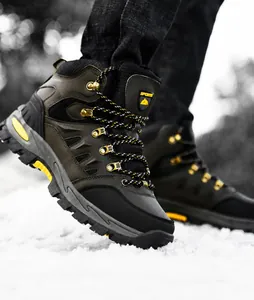 Dettaglio della suola antiscivolo di scarponi da trekking verde oliva sulla neve