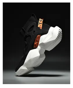Macro shot of high-top sock sneakers featuring vibrant orange straps and thick white soles