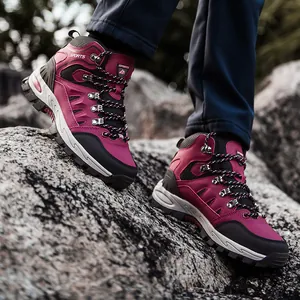 Scarponi da trekking outdoor per uomo e donna in rosso scuro su terreno roccioso