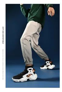 Detail of breathable high-top sock sneakers with orange straps and cushioned thick soles