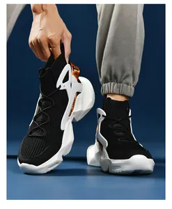 Close-up of black high-top knit sock sneakers with thick white soles and orange pull tabs