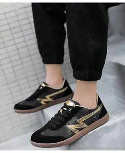 Macro shot of low-top sneakers with black suede stitching and gold lightning logo