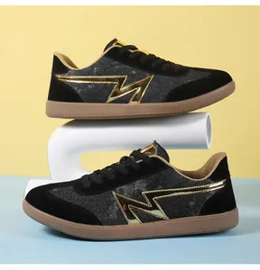 Detail of retro sneakers with black denim, gold flash logo, and classic gum soles
