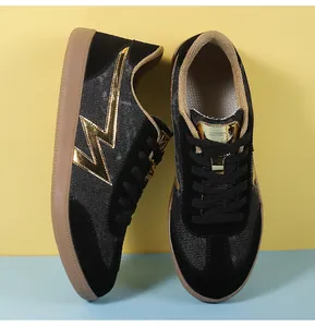 Close-up of retro black sneakers with golden lightning bolt detail and brown gum soles