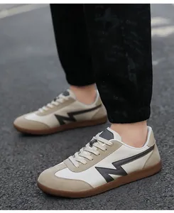 Close-up of retro training shoes with beige leather, khaki suede, and gum rubber soles
