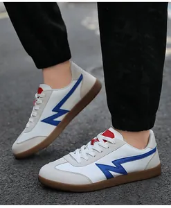 Detail view of white leather trainers with blue accents and gum rubber outsoles