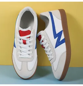 Detail of retro sneakers with white leather, gray suede toe, and brown gum sole