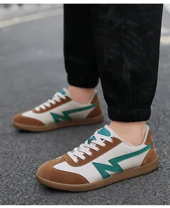 Detailed close-up of brown suede retro sneakers featuring green logo and rubber sole