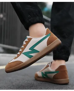 Close-up of retro low-top sneakers with brown suede and green Z-pattern on the street