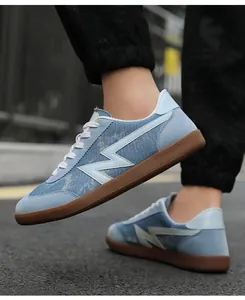 Close-up of low-top denim texture sneakers with white lightning logo on a brown rubber sole