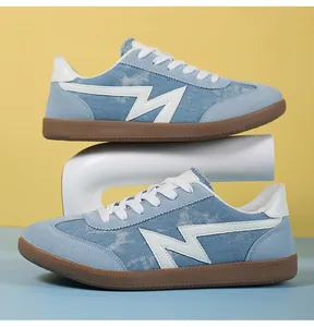 Detailed close-up of blue denim and white leather low-top sneakers on a stylized stand