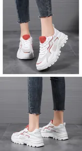 Dettaglio di sneaker chunky bianche con mesh traspirante e linee ondulate rosse