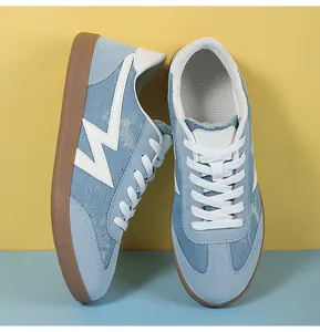 Close-up of light blue suede retro sneakers with brown rubber sole and white laces