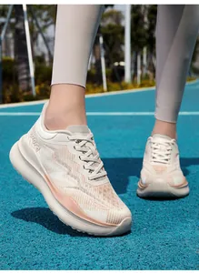 Detail van ademend mesh bovenwerk en Sport zool op crème roze hardloopschoenen