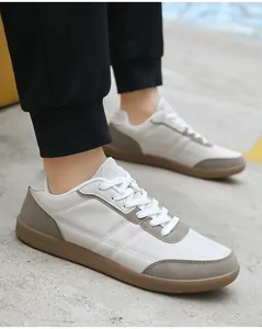 Vista dettagliata delle scarpe da ginnastica bianco crema con suole in gomma marrone