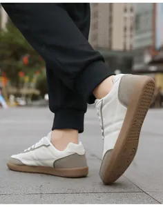 Dettaglio della suola in gomma marrone antiscivolo su sneaker bianche da allenamento