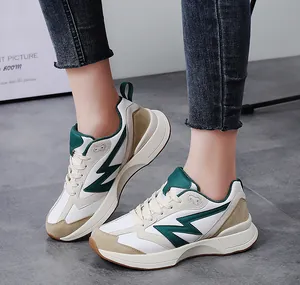 Detail shot of vintage low-top sneakers in white and beige with green accent on feet