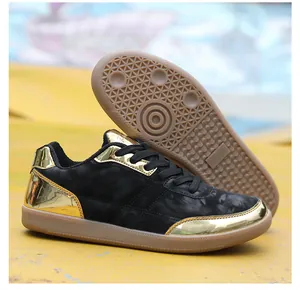Dettaglio di scarpa sportiva nera e oro con suola in gomma ambra antiscivolo premium