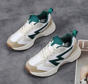 Detailed top-down view of retro chunky sneakers with white leather and green mesh stitching