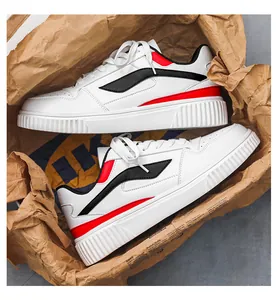 Λεπτομέρεια από λευκά δερμάτινα sneakers με μαύρα κύματα και κόκκινες λεπτομέρειες στη σόλα