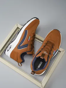 Vue détaillée des baskets marron avec semelle à coussin d'air et bande latérale en V