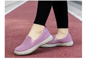 Detalle de zapatos de malla morados para mujeres mayores en una pista roja