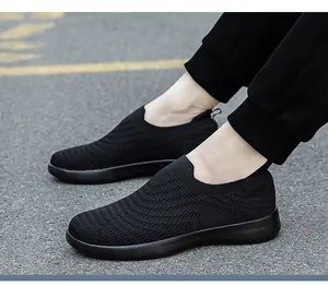 Macro view of black knit slip-on walking shoes showing breathable mesh texture and EVA sole