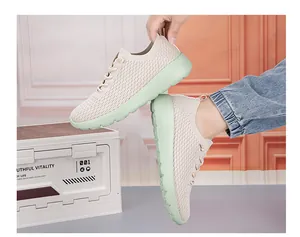 Close-up of beige breathable knit upper and light green chunky sole on sports sneaker
