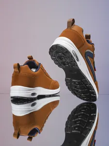 Détail de chaussures de sport kaki avec bandes latérales et semelle à coussin d'air visible