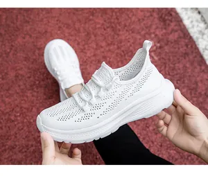 Dettaglio della maglia traspirante bianca e dei lacci su scarpe sportive leggere