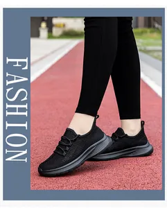 Dettaglio delle scarpe da ginnastica in maglia nera traspirante su pista da corsa rossa