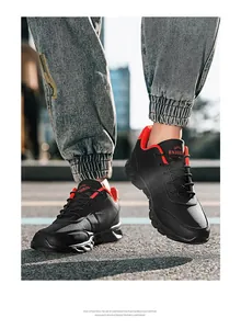 Inquadratura dinamica di scarpe sportive da uomo leggere nere e rosse per uso esterno