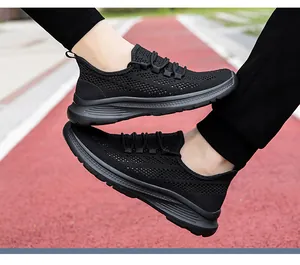Dettaglio di scarpe da corsa in mesh nero traspirante su pista di atletica leggera rossa