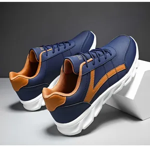 Dettaglio della sneaker blu navy con striscia a V marrone e suola in gomma bianca