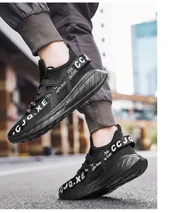 Dettaglio della sneaker in rete nera con nastro a lettere bianche e suola ammortizzata