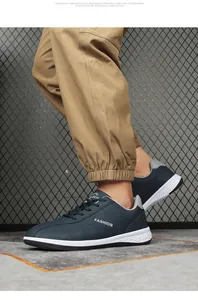 Detail van donkerblauwe leren casual herensneaker met fashion-logo en witte zool