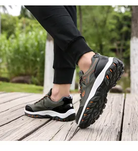 Outdoor model shot of olive green hiking shoes on a wooden path featuring MISTT logo