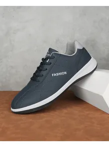 Detailweergave van marineblauwe lederen sneakers met witte FASHION-print aan de zijkant