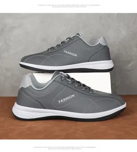 Gedetailleerd zijaanzicht van grijze leren herensneakers met rubberen honingraatzool