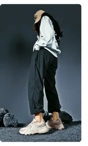 Chunky beige sneakers paired with street style joggers and a graphic hoodie in a studio