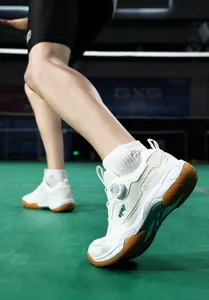 Detail of breathable badminton shoes featuring a quick-adjust knob buckle and rubber gum sole