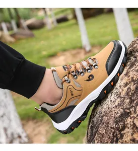 Close-up of khaki and black hiking shoes on grass showing anti-slip rubber soles